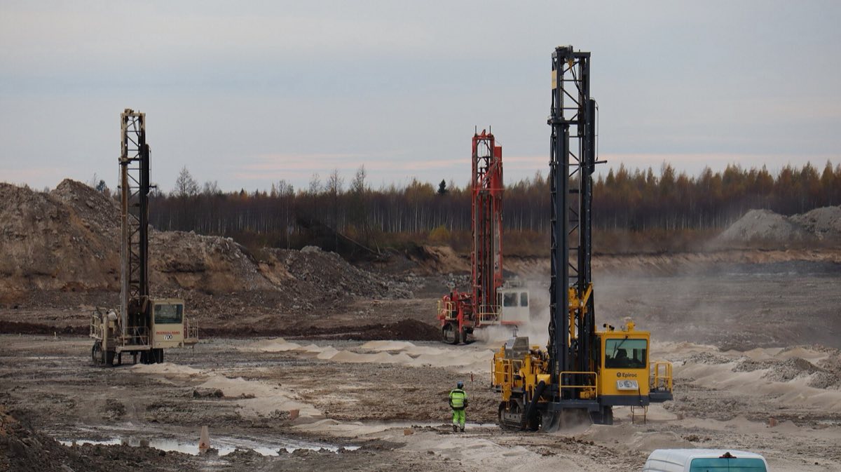 Track-mounted rig drilling blast holes at an open-pit mine